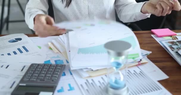 Femme d'affaires travaille avec des tableaux financiers et compte sur la calculatrice - Séquence, vidéo