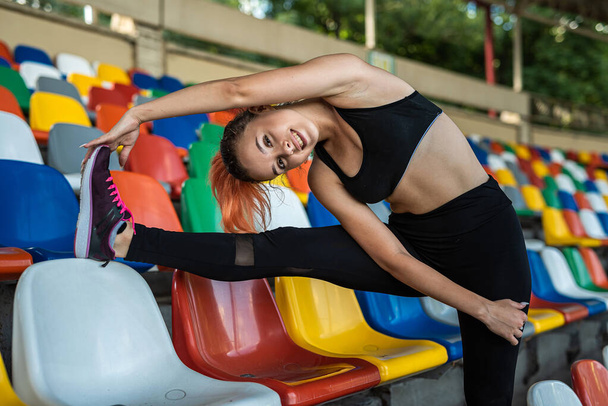 female trainer doing yoga or pilates exercise against green stadium background. Active Lifestyle, healthy - Photo, Image
