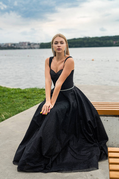beautiful woman in black fashion dress posing near lake, summer time - Foto, immagini