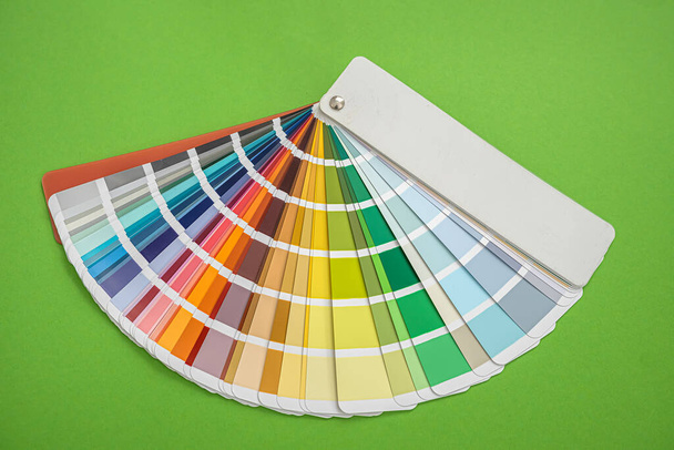 Auf grünem Hintergrund stehen farbige neue Fächervorlagen mit unterschiedlichen Farben zur Designauswahl. Gestaltungskonzept - Foto, Bild