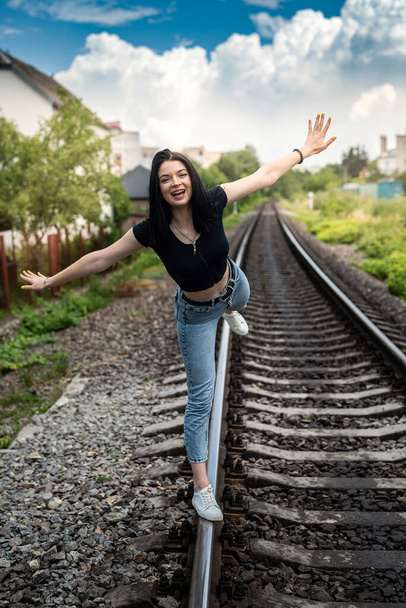 πορτρέτο της όμορφης νεαρής γυναίκας σε καλοκαιρινό ύφασμα ποζάροντας κοντά σε σιδηρόδρομο, ταξίδι  - Φωτογραφία, εικόνα