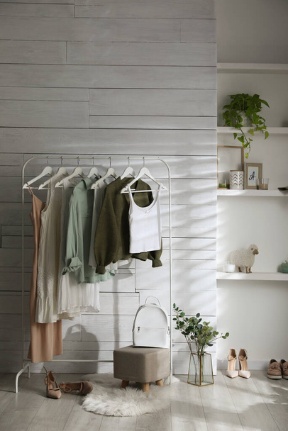 Rack with different stylish clothes, shoes and decorative elements in dressing room. Interior design - Fotó, kép