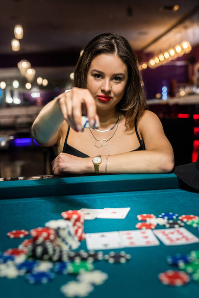 gelukkige mooie vrouw spelen poker aan groene casino tafel. Gokconcept - Foto, afbeelding