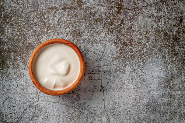 Cream sauce in a sauce pot on a restaurant stone table - Foto, Bild