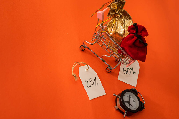 pink shopping cart watch gifts beautiful with discounts lie on orange background. Discount concept. Black friday concept - Photo, Image