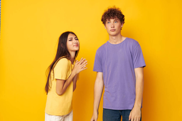 cute young couple in colorful t-shirts posing friendship fun yellow background unaltered - Фото, зображення