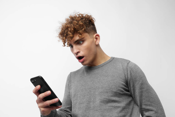 Attractive man talking on the phone posing emotions light background - Foto, Imagem