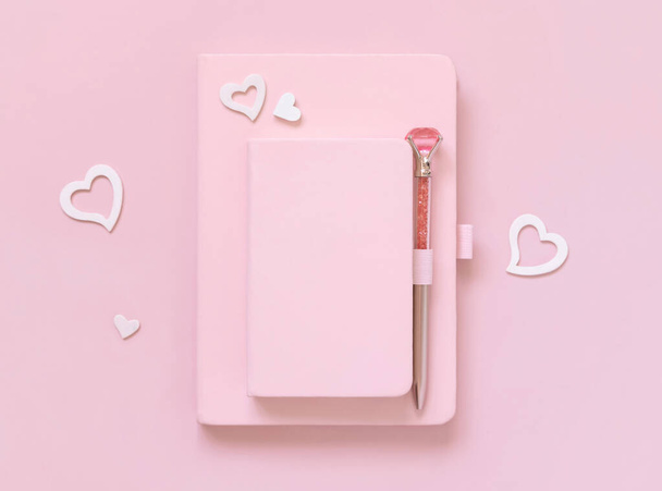 Pink hardcover notebooks, decorative gemstone pen and hearts on light pink top view. Textbook mockup, planner cover with place fot text. Educational, valentines day and girly concept - 写真・画像