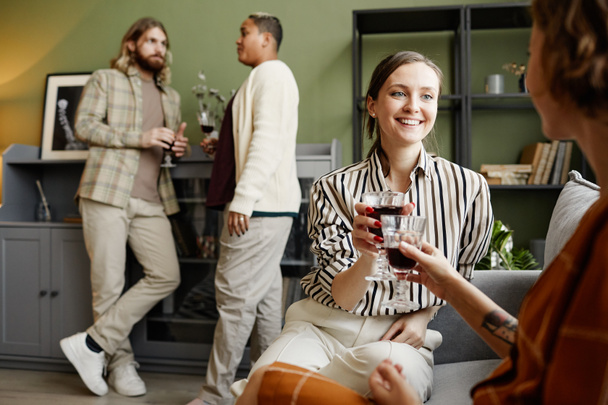 Happy friends drinking wine at a party - 写真・画像