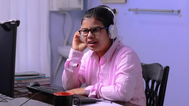 Intialainen nainen opettaja vaaleanpunainen paita videoneuvottelut tietokoneella kotona - Materiaali, video
