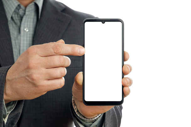 Κοντινό πλάνο, επιχειρηματίας χέρι με κοστούμι κατέχει έξυπνο τηλέφωνο και δείχνει οθόνη smartphone του mockup, θέση για τη διαφήμιση των προϊόντων ή αντίγραφο κειμένου χώρο - Φωτογραφία, εικόνα