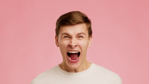 Emotional Guy Shouting Looking At Camera Standing Over Pink Background - Video