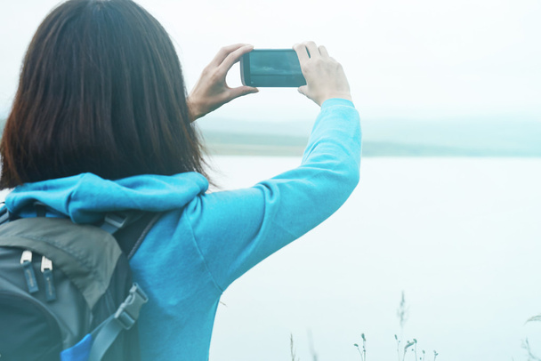 Hiker woman takes photographs on nature - Zdjęcie, obraz