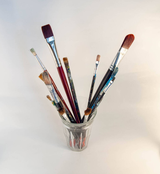 Paintbrushes in a glass jar on white background - Foto, afbeelding