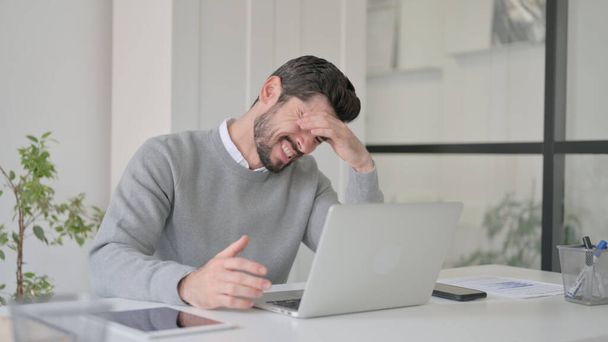 Homme réagissant à la perte tout en utilisant un ordinateur portable - Photo, image