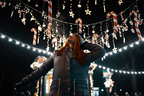 Women enjoy winter holiday lights in the evening - Foto, Imagem