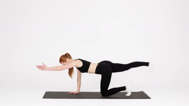 Femme sportive faisant de l'exercice à l'intérieur, debout à quatre pattes, levant les mains et les jambes - Séquence, vidéo