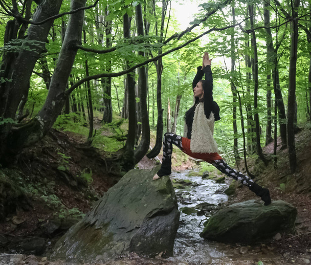 woman demonstrates yoga pose near the stream - Zdjęcie, obraz