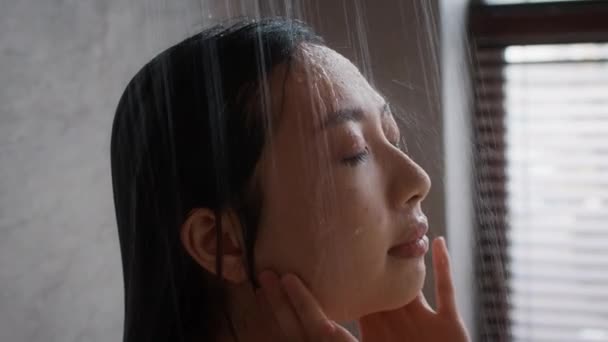ウェルネスコンセプト。シャワーで若いアジアの女性の閉鎖ショット - 映像、動画