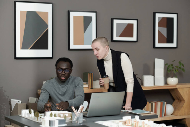 Confident African male architect presenting layout of new yard to colleague - Photo, Image