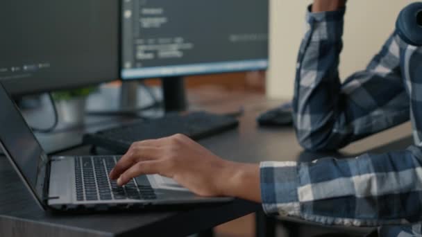 Zbliżenie rąk programisty wpisując kod uczenia maszynowego na klawiaturze laptopa przed ekranami komputera - Materiał filmowy, wideo