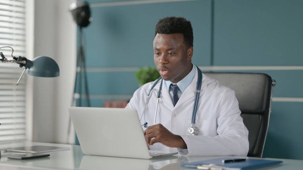 Африканський лікар розмовляє на відеозв'язку ноутбуці в клініці
  - Фото, зображення