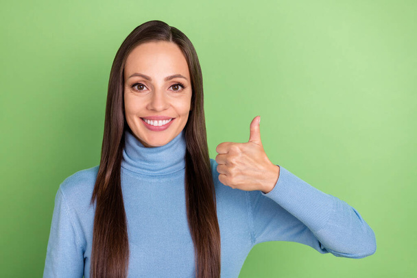 Photo of cheerful lady raise thumb up approve tips solution wear blue turtleneck isolated green color background - Foto, immagini