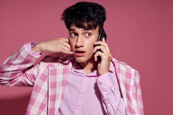 portrait of a young man with a phone in hand pink blazer fashion elegant style Lifestyle unaltered - Fotoğraf, Görsel