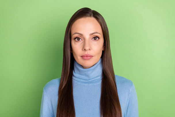 Photo of calm focused brunette lady look camera wear blue turtleneck isolated green color background - Fotoğraf, Görsel