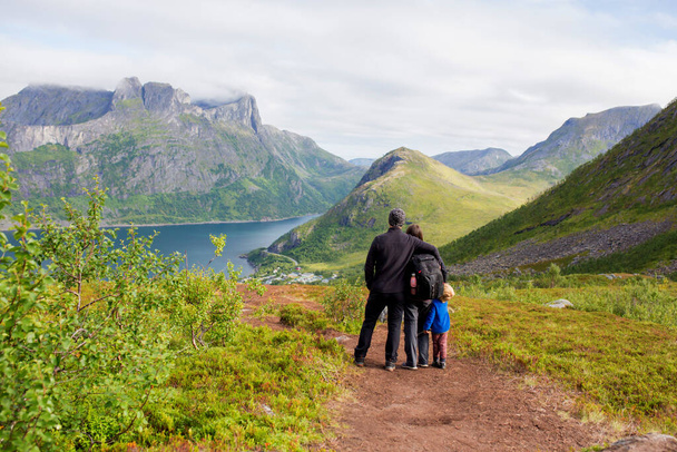Happy family, standing on a rock and looking over Segla mountain on Senja island, North Norway. Amazing beautiful landscape and splendid nature in scandinavian country - Valokuva, kuva