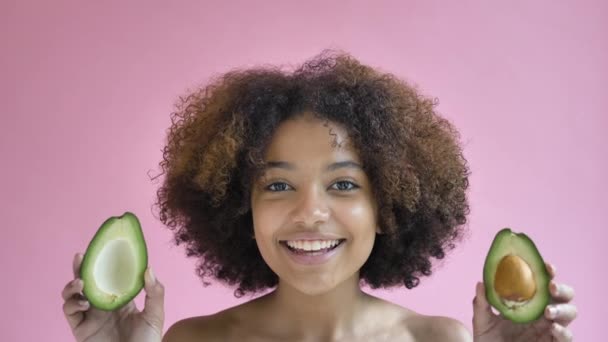 Professional Afro American model poses with avocado halves - Filmagem, Vídeo