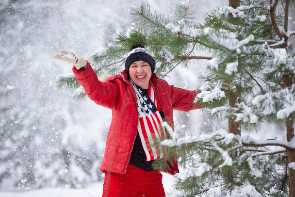 Szczęśliwa kobieta w średnim wieku w zimowym lesie na spacerze. - Zdjęcie, obraz