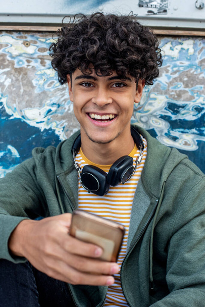 Close up portrait happy young smiling man holding mobile phone  - Фото, изображение
