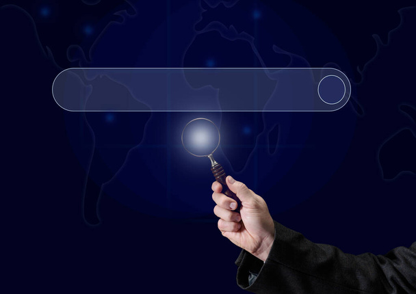 a man's hand holds a magnifying glass on the background of a template for entering and searching information on the Internet. Globalization, availability of information - Foto, Imagem