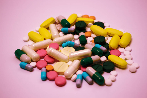 Stapel von Medikamenten in Kapseln und Pillen in verschiedenen Farben auf weißem Hintergrund - Foto, Bild
