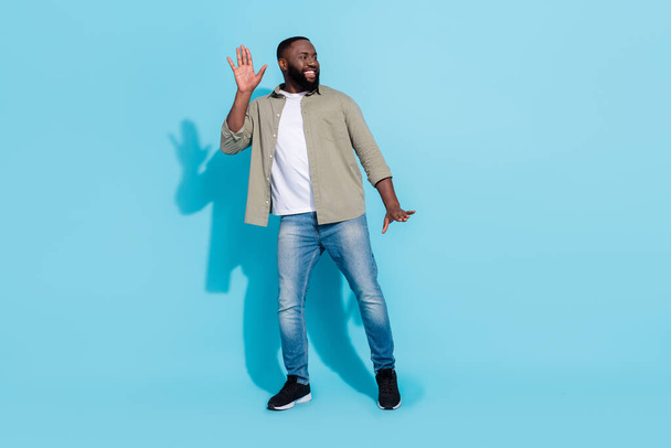 Full length photo of young cheerful man have fun dance look empty space isolated over blue color background - Foto, Imagen