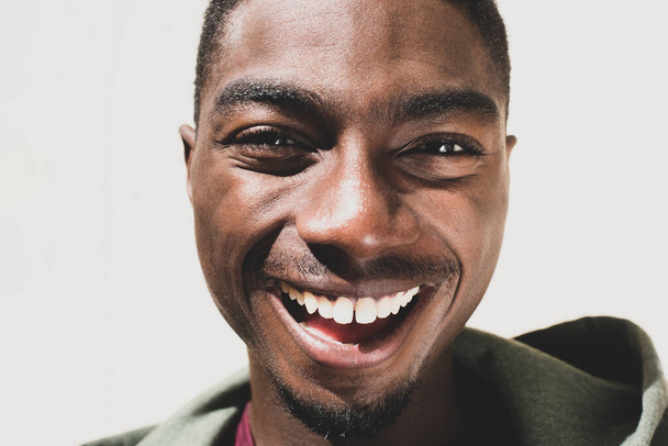 Primer plano retrato riéndose hombre afroamericano por fondo blanco  - Foto, imagen