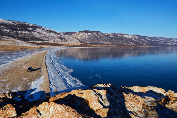 Frozen Lake Baikal. View of the transparent ice from Cape Tsagan-Khushun. Winter travel in Russia.  - Foto, Imagen