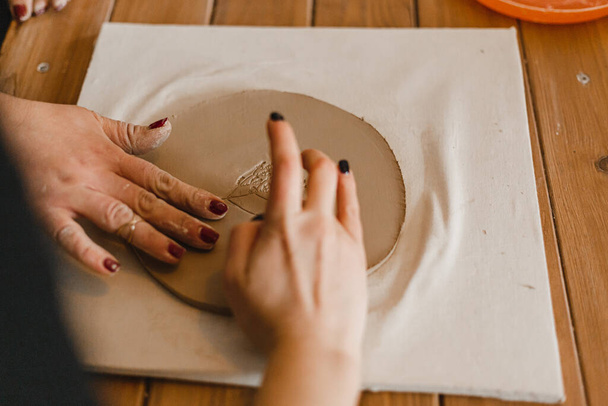Weibliche Hände stellen Geschirr aus Ton her - Foto, Bild