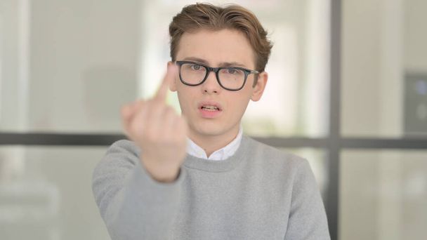Retrato de un joven enojado mostrando el signo del dedo medio - Foto, imagen
