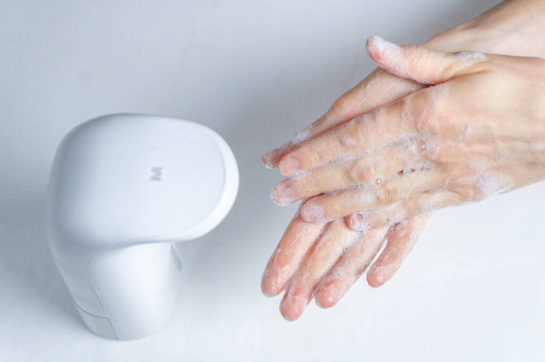 Hand cleaning with a non-contact automatic antiseptic solution or soap dispenser to prevent pandemic and disease - Foto, Imagem