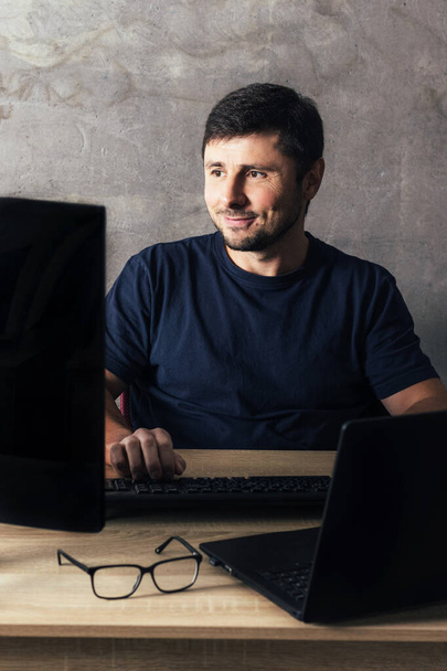 Mies toimistopöydällä, työskentelee kannettavan tietokoneen parissa - Valokuva, kuva