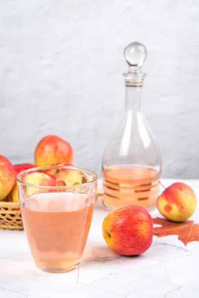 Close-up of a glass of apple juice with apples on a light background. - Fotografie, Obrázek