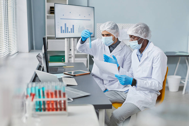 Men examining samples in tubes - Photo, Image