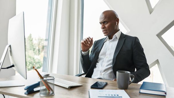 Focused black male businessman watch on computer - Zdjęcie, obraz