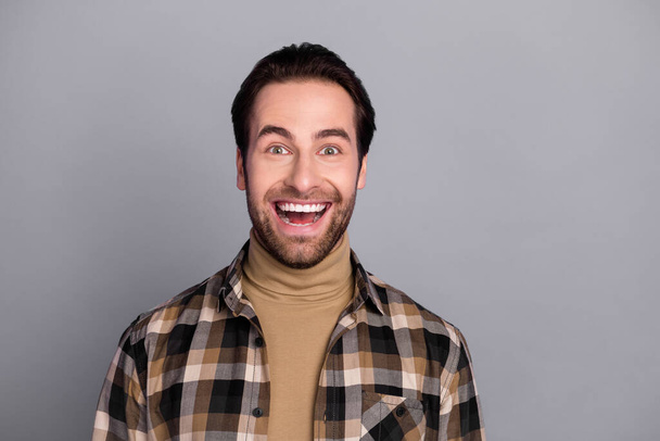Photo of funny impressed man wear plaid shirt smiling open mouth isolated grey color background - Foto, immagini