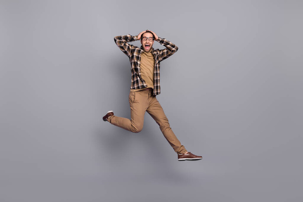 Full length body size view of attractive cheerful guy jumping having fun good mood isolated over grey color background - Foto, Imagem