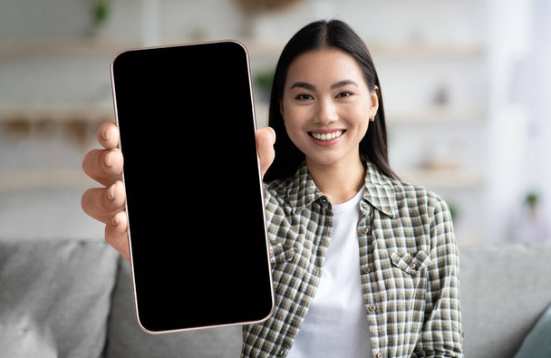 Happy Asian Woman Showing Big Smartphone With Blank Blank Screen At Camera - Foto, Imagen