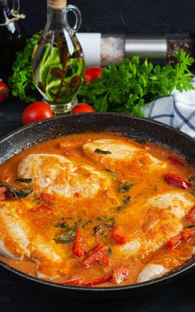Stew chicken breast with tomato, pepper and spinach in pan - Valokuva, kuva