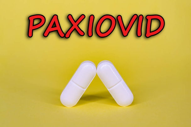 Paxiovid. Pfizer antiviral against Covid-19 (Coronavirus). Revolutionary pills for Covid. Background with pills on yellow background. Horizontal photography. Design with text. - Fotoğraf, Görsel